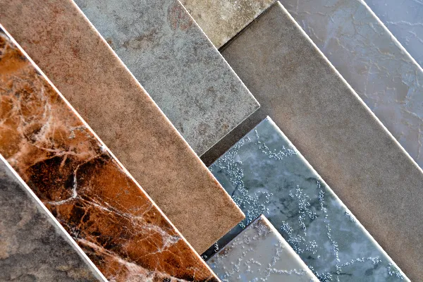 Rectangular stone and ceramic tiles in various colors and marble patterns are arranged in a diagonal overlapping layout.