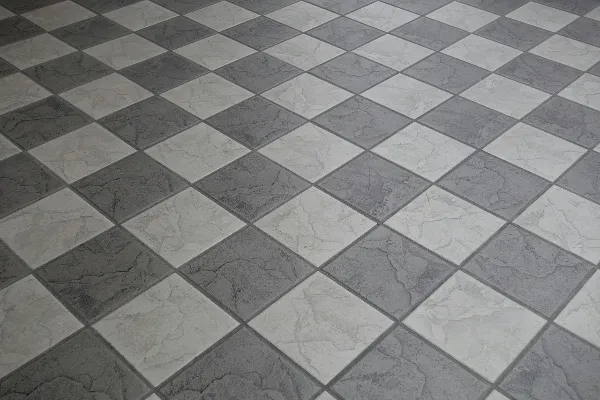 A floor with a checkerboard pattern made of alternating light and dark gray square tiles.