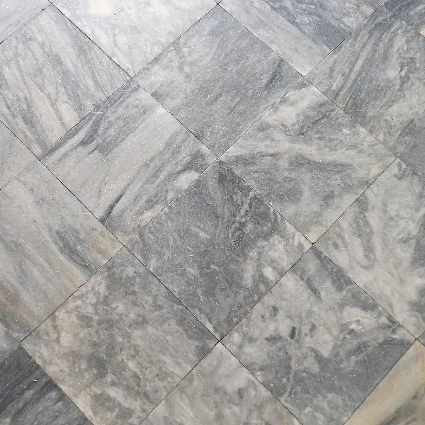 A close-up view of gray marble floor tiles arranged in a diagonal checkerboard pattern.